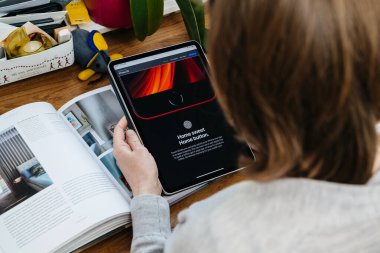 iPhone Se 'ye bakan kadın iPad Pro tabletinde yeni ev düğmesi