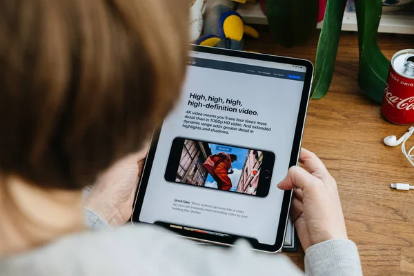 Γυναίκα ψάχνει για το νέο iPhone Se στο iPad Pro tablet — Φωτογραφία Αρχείου
