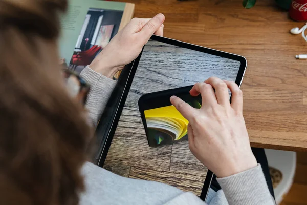 Mujer mirando en el nuevo iPhone Se en la tableta iPad Pro — Foto de Stock