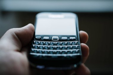 Adamın eli pencerede Blackberry RIM akıllı telefonu.