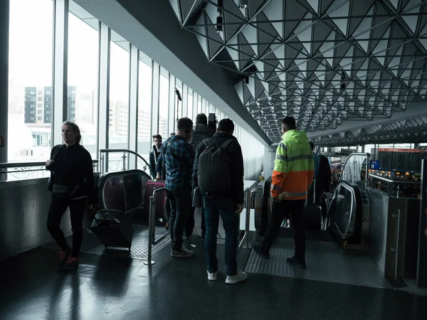 Група людей і оператора знімають ескалатор всередині Франкфуртського міжнародного аеропорту. — стокове фото