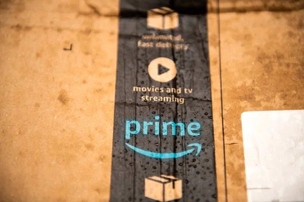 Detailed macro shot of wet Amazon Prime parcel cardboard with multiple water drops — Stock Photo, Image