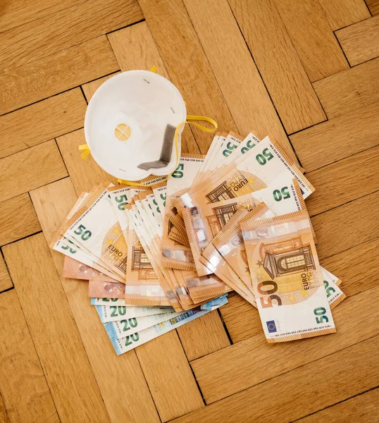 Des milliers d'euros billets de banque et un masque de protection respiratoire FFP2 — Photo