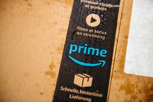 POV male hand holding pointing at wet Amazon Prime parcel cardboard — Stock Photo, Image