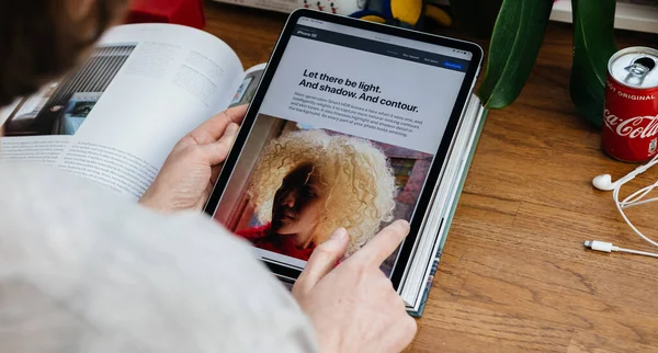 Mujer mirando en el nuevo iPhone Se en la tableta iPad Pro — Foto de Stock