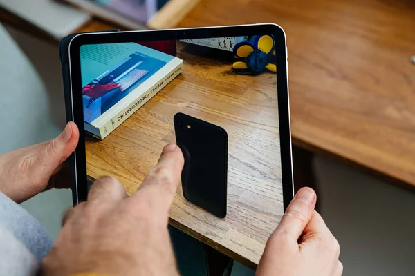 Vrouw op zoek naar nieuwe iPhone Se op iPad Pro tablet — Stockfoto