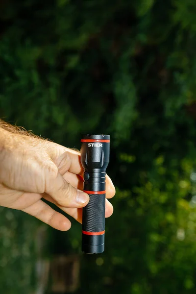 Vertikální snímek mužské ruky držící novou mini LED baterku — Stock fotografie