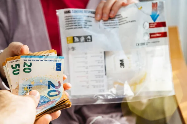 Man offering stack of money banknotes for surgical 3M Hand Sanding Respirator — Stock Photo, Image