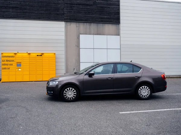 法国巴黎 2020年3月29日 新棕色Skoda Octavia汽车在黄色亚马逊锁机前的侧面视图 在线零售商亚马逊提供的自助服务包交付服务 — 图库照片