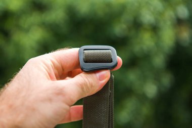 Yeşil doğal arka plana karşı el ele tutuşan adam yeni sürtünme kemeri renginde.