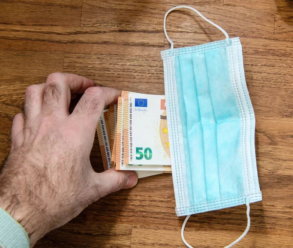 50 euros bank notes under surgical procedure medical face mask during Coronavirus worldwide