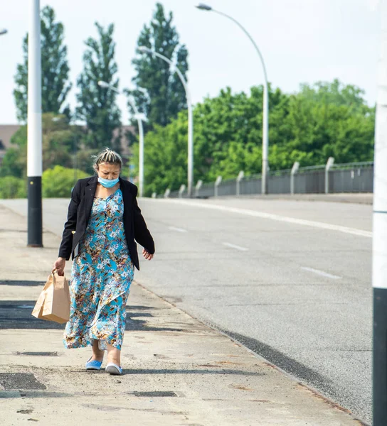 Frau mit Maske geht auf Brücke über deutsch-französische Grenze — Stockfoto