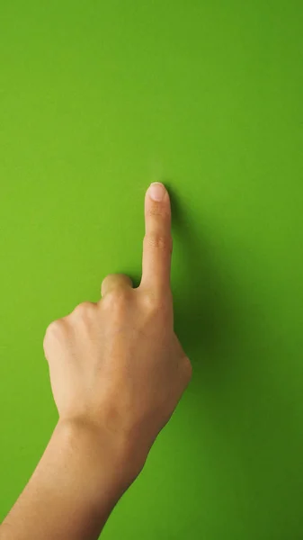 Human finger touching or pointing on green screen.