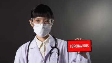 Çin 'in Wuhan bölgesindeki Coronavirus salgınını temsil eden stüdyo siyah arka planda N95 maskeli Asyalı genç kadın doktor..