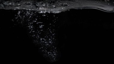 Su altı kabarcıkları, su sıçratma ve yüzme ve karbonat içeceğini temsil eden siyah renk arkaplanı. Gazoz, kola ve doğal gazlı su, ferahlatıcı ve ferahlatıcı bir konsept için kullanılabilir.