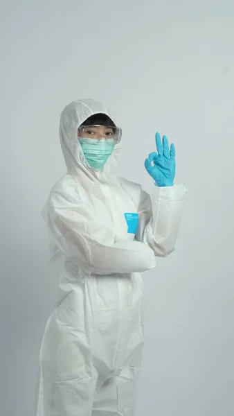 Asian doctor woman wear PPE suit or Personal Protective Equipment and medical mask and gloves which use for protect covid-19 virus pandemic from Wuhan China and talking about quarantine for safety