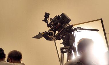 Çekim ekibinin ve stüdyodaki HD video kamera ve ekipmanların arkasında büyük tripod, yumuşak kutu ışığı, monitörler, çevrimiçi film veya film yapmak için lens ya da canlı yayın yapan