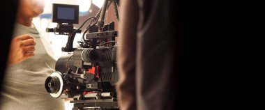 Çekim ekibinin ve stüdyodaki HD video kamera ve ekipmanların arkasında büyük tripod, yumuşak kutu ışığı, monitörler, çevrimiçi film veya film yapmak için lens ya da canlı yayın yapan