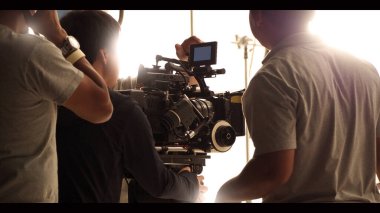 Çekim ekibinin ve stüdyodaki HD video kamera ve ekipmanların arkasında büyük tripod, yumuşak kutu ışığı, monitörler, çevrimiçi film veya film yapmak için lens ya da canlı yayın yapan