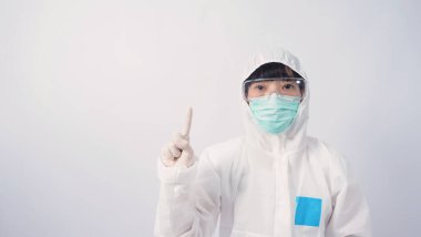 PPE kostümlü ya da Kişisel Koruma Ekipmanı 'ndaki doktor, salgın virüsünü korumak ve mücadele etmek için beyaz renkli tıbbi lastik eldivenler, temiz gözlükler ve yeşil N95 maskesi taktığını belirtiyor.