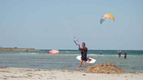 Kitesurfer Kráčí Pláži Prknem Drakem Obloze — Stock video