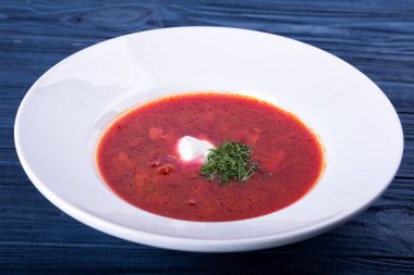 Beyaz bir tabak içinde kırmızı borsch