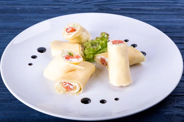 Rouleaux de lavash au saumon avec fromage et herbes sur plaque de verre, vue rapprochée — Photo