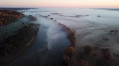 4K hava bakış açısı. Nehrin üzerinde güneşli ve sisli bir sabah, güneşin altında sis..