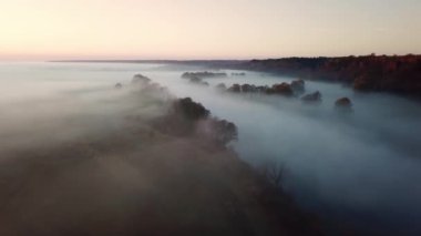 4K hava bakış açısı. Nehrin üzerinde güneşli ve sisli bir sabah, güneşin altında sis..
