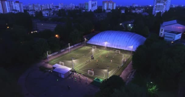 Ciudadanos urbanos aéreos entrenando en campo de fútbol estableciendo tiro 4K — Vídeo de stock