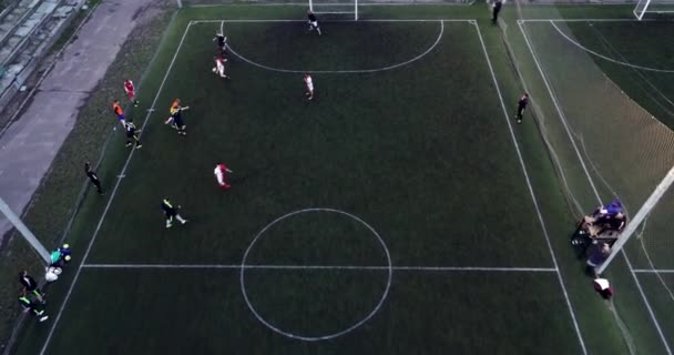 Vista aérea del campo de fútbol por la noche con jugadores de fútbol amateur jugando el juego en la ciudad. — Vídeo de stock