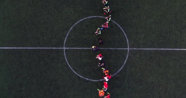 Luchtfoto van voetbalveld 's nachts met amateurvoetbalspelers die het spel spelen in de stad. — Stockvideo