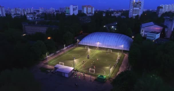 एरियल शहरी सिटीस्केप लोग फुटबॉल फुटबॉल पिच पर प्रशिक्षण शॉट 4K स्थापित करते हैं — स्टॉक वीडियो