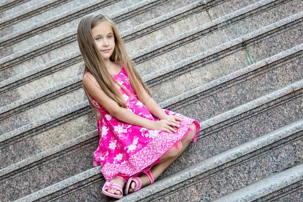 Neşeli küçük güzel kız dışarıda poz veriyor