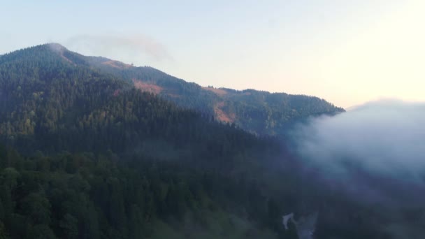 Dağların tepesinde bulutlar arasında uçuyor. Yüksek tepeler, harika sabah güneşi, doğal manzara. — Stok video