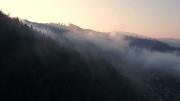 Dağların tepesinde bulutlar arasında uçuyor. Yüksek tepeler, harika sabah güneşi, doğal manzara. — Stok video