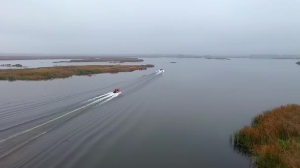 Fishermen riding boat blue for fishing in the morning foggy. View of the traditional houses fishermen built from bamboo in the sea at the river mouth before entering the big sea. — Stock Video