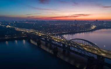 Gece şehrinin fenerle aydınlatılmış köprüsünde yoğun bir trafik var..