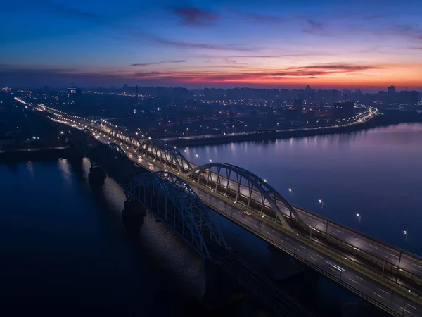 Tráfico ocupado en el puente iluminado por linternas de la ciudad nocturna . — Foto de Stock