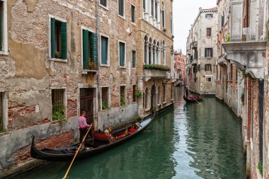 Venedik kanallarının güzel bir fotoğrafı gondolların turistleri gezdirdiği ve taşıdığı