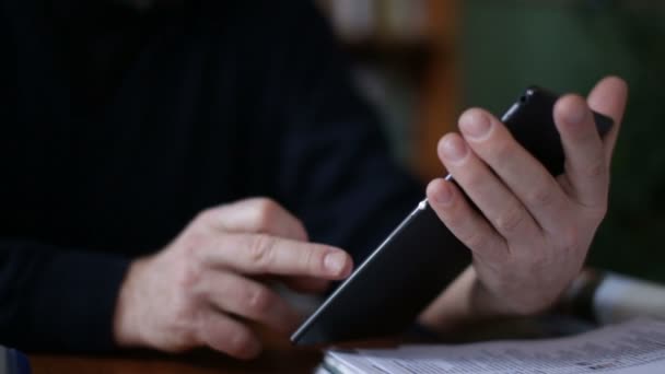 Starší muž pomocí tabletu sedí na bílé pohovce v obývacím pokoji. Počáteční a koncové rozmazané. — Stock video