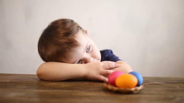 Mladý chlapec hraje s velikonoční vajíčka doma — Stock video