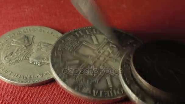 Monedas antiguas cayendo sobre una mesa roja — Vídeos de Stock