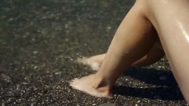 Piernas lavadas con agua de mar. Un montón de pies en la playa de arena. Las olas fluyen por las piernas. Uñas en agua de mar . — Vídeo de stock
