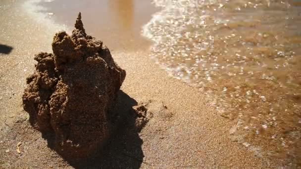 Castle on the sand is washed off by a sea wave — Stock Video
