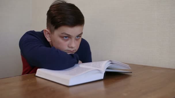 Boy dreams while reading a book — Stock Video