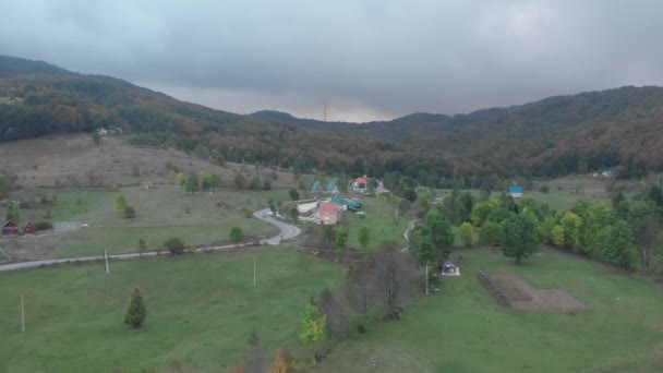 Letecký výhled, větrná farma, kopcovitá oblast se spoustou zeleně. V popředí je vesnice — Stock video