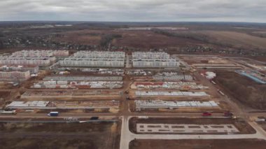 Bir inşaat tesisinde çalışan çok sayıda kazıcı ve vinç de dahil olmak üzere büyük bir inşaat sahası. Yukarıdan hava üstü görünümü