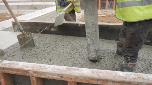Заливка бетонної суміші з цементного міксера на бетонну опалубку. Завершено вирівнювання плити і заливка бетонної підлоги фундаментом . — стокове відео