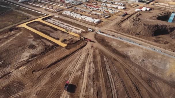 Bir inşaat tesisinde çalışan çok sayıda kazıcı ve vinç de dahil olmak üzere büyük bir inşaat sahası. Yukarıdan hava üstü görünümü — Stok video